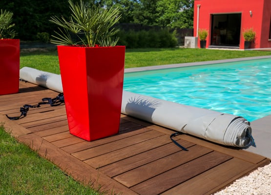 couverture de sécurité à barres pour piscine enroulée sur plage